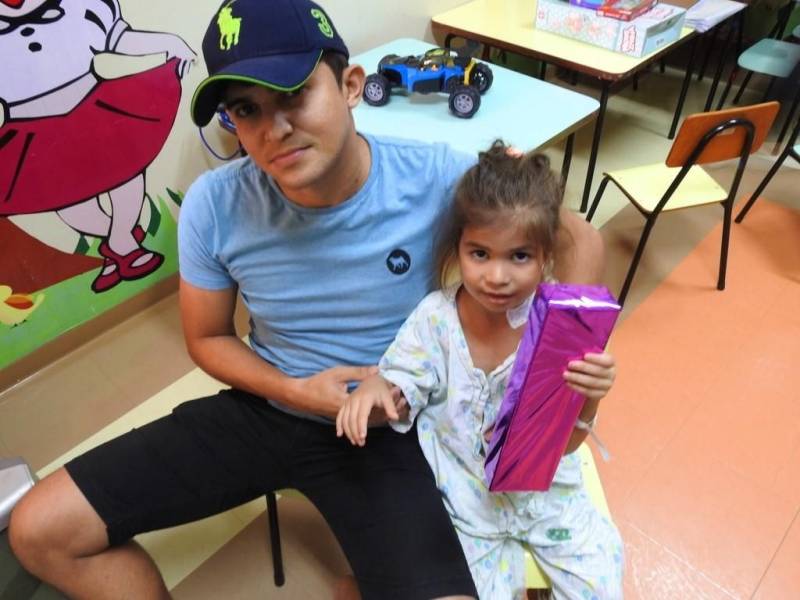 “Ela é muito bonita”. Assim a pequena Evelin Victhória Brigel Sousa, 4 anos, definiu a nova boneca que ganhou, na tarde desta quinta-feira (29), no Hospital Regional Público da Transamazônica (HRPT), em Altamira, no sudoeste do Pará. A menina se recupera na clínica pediátrica da unidade e foi uma das crianças presenteadas pelos “brinquedos de Páscoa”, em uma ação do Grupo de Trabalho de Humanização. A direção reuniu brinquedos doados pelos próprios colaboradores e entregou às crianças internadas no hospital, na clínica e na UTI pediátricas. Os usuários que puderam ainda assistiram a uma sessão de cinema na brinquedoteca, acompanhados dos pais, que aprovaram a iniciativa. Na foto, Efrain Lima Sousa, pai da Evelin.

FOTO: ASCOM / HRPT
DATA: 29.03.2018
ALTAMIRA - PARÁ <div class='credito_fotos'>Foto: ASCOM HRPT   |   <a href='/midias/2018/originais/3a45e6b4-919d-4405-b26b-b84f12b899d7.jpg' download><i class='fa-solid fa-download'></i> Download</a></div>