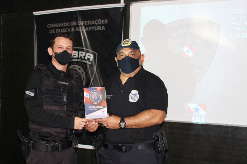 tttttttttttSecretário Jarbas Vasconcelos entrega premiação ao policial Fabrício Henrique, vencedor do concurso que elegeu o brasão da Polícia Penal