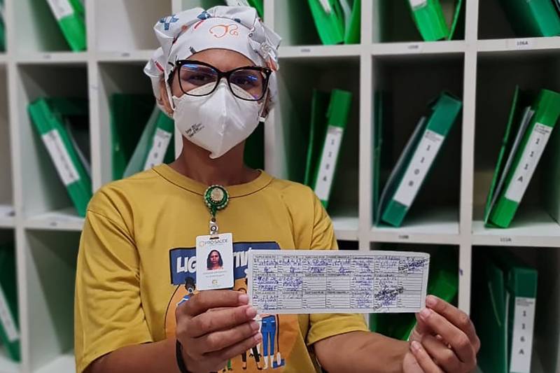 Orgulhosa de estar em dias, Rosileia Saldanha mostra o seu cartão de vacinação