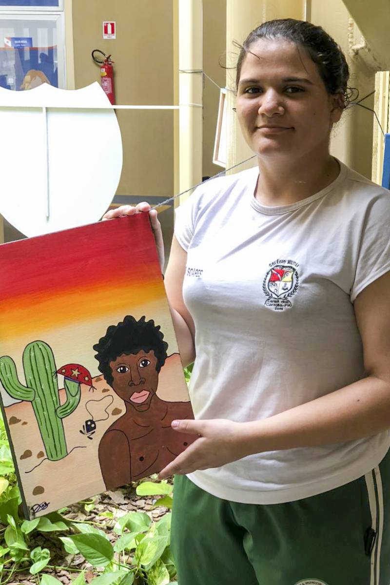 A estudante Stefani Beatriz, de 14 anos, expondo sua obra de arte.
