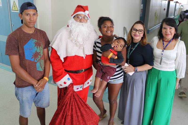 João e os pais sorriem ao lado de Papai Noel