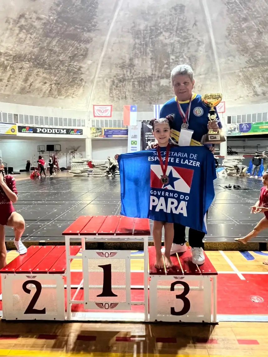 Atleta Elisa Delgado Torres ao lado do professor Ulisses  Lima, no pódio da competição. 