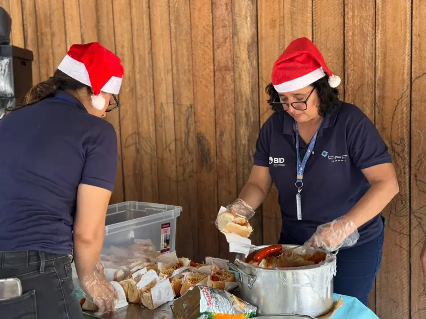 Monitoras do Prodesan preparam o cachorro quente durante a ação na biblioteca comunitária 