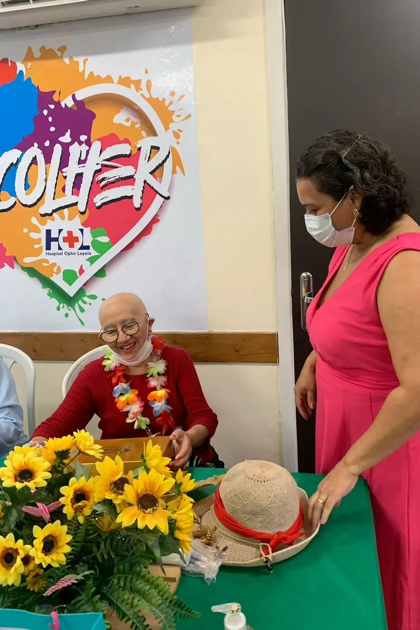 Paciente Maria Rita no Espaço Acolher na quimioterapia recebendo sua peruca 