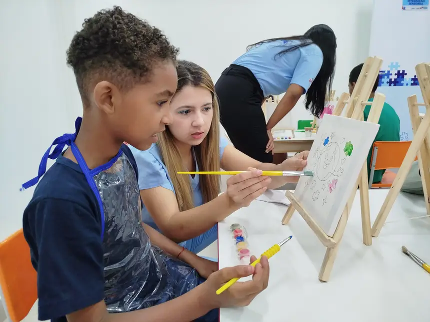 Criança é acompanhada de perto em atividade lúdica no Núcleo de Atendimento ao Transtorno do Espectro Autista (Natea)