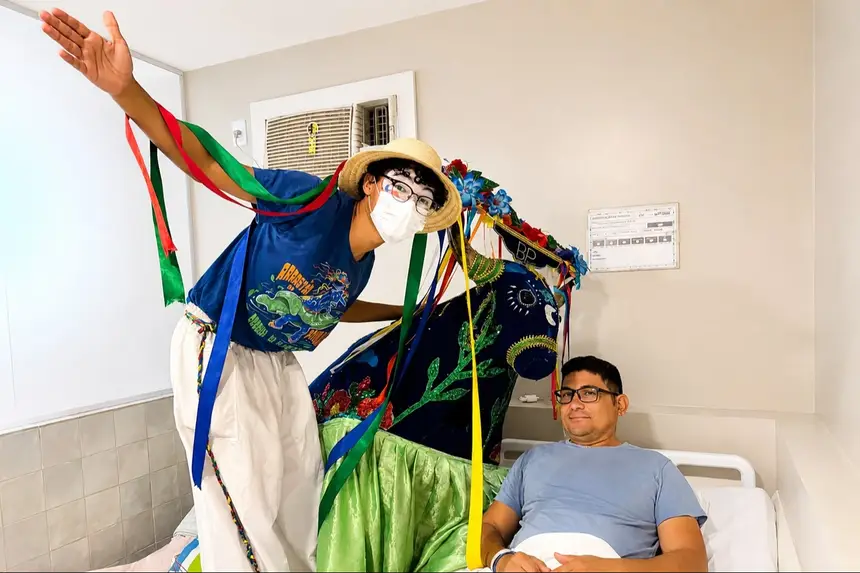 O paciente Marciel da Silva recebeu o carinho do Boi Azul e de pernaltas do Instituto Arraial do Pavulagem durante a visita ao Hospital Ophir Loyola.